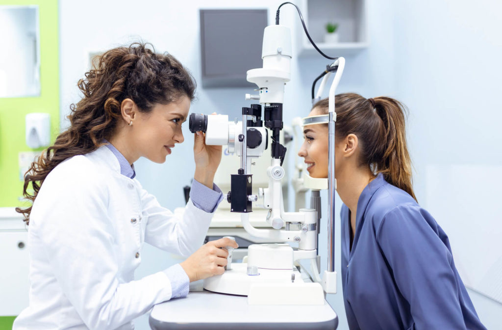 A female optometrist looking at a female patient's eyes