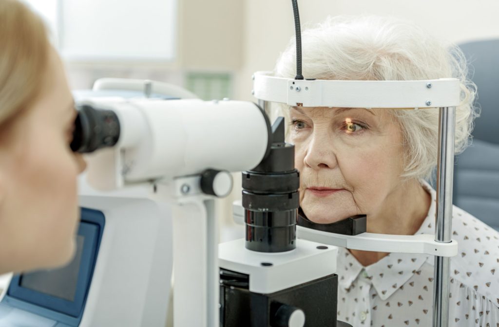 An older female patient getting her eyes examined for eye diseases and conditions like glaucoma at the optometrists office