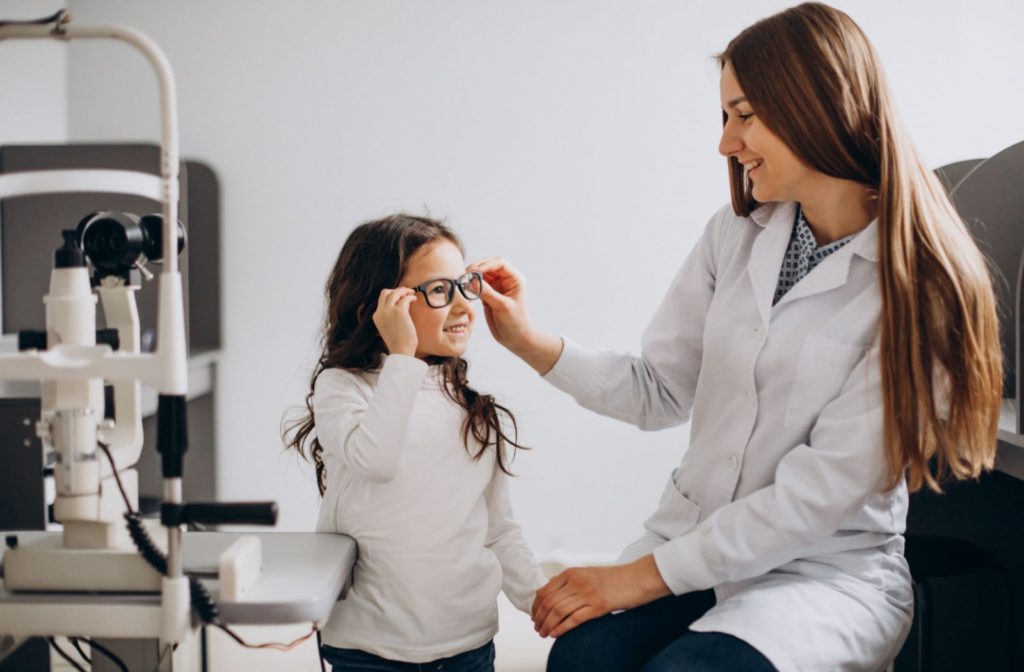 A young girl receives glasses from an optometrist to manage myopia